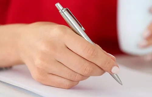 A Hand Filling Out Forms