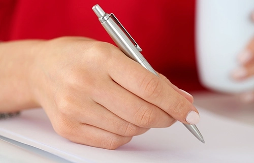 A Hand Filling Out Forms