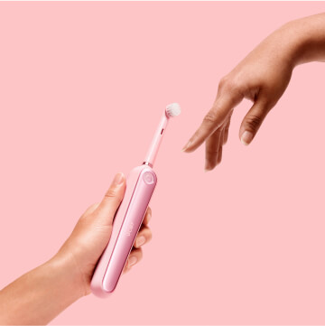 A hand pointing to electric toothbrush