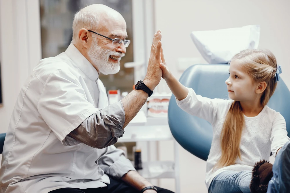 A Dentist Making A Hand Clap to his Child Patient